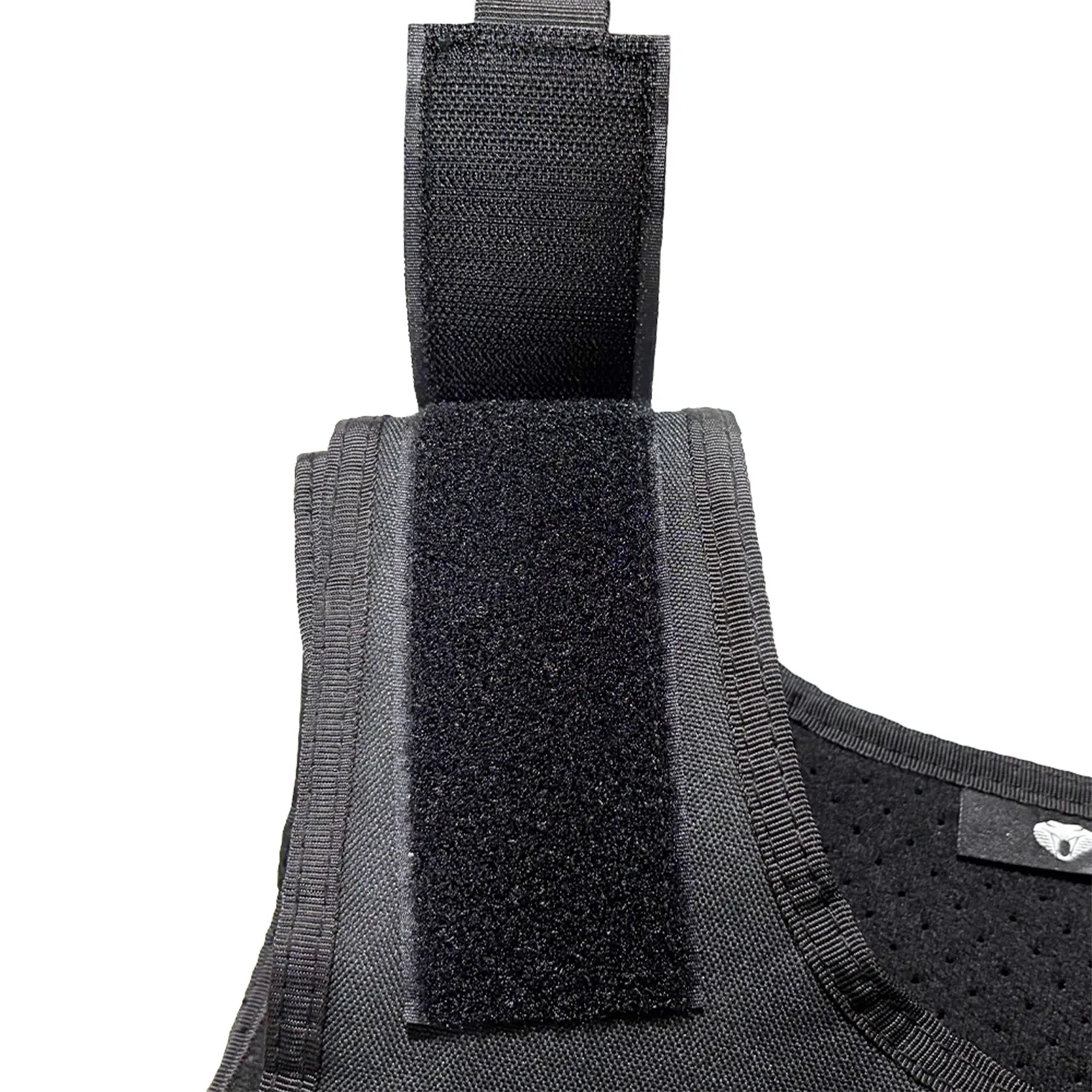 Close-up of shoulder hook-and-loop adjustment on black tactical vest