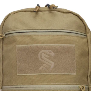 Close-up of tan backpack front hook-and-loop patch panel with zipper pocket above