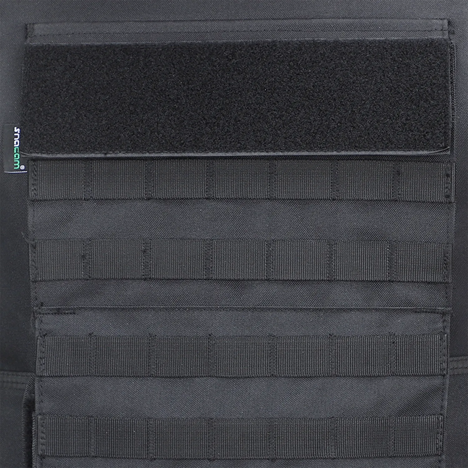Close-up of MOLLE webbing and hook-and-loop panel on black tactical vest