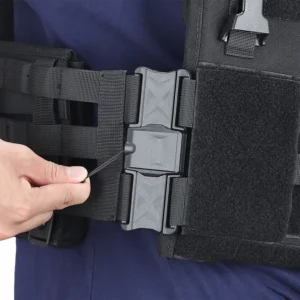 Hand pulling release cord on magnetic buckle of a black tactical cummerbund attached to a plate carrier